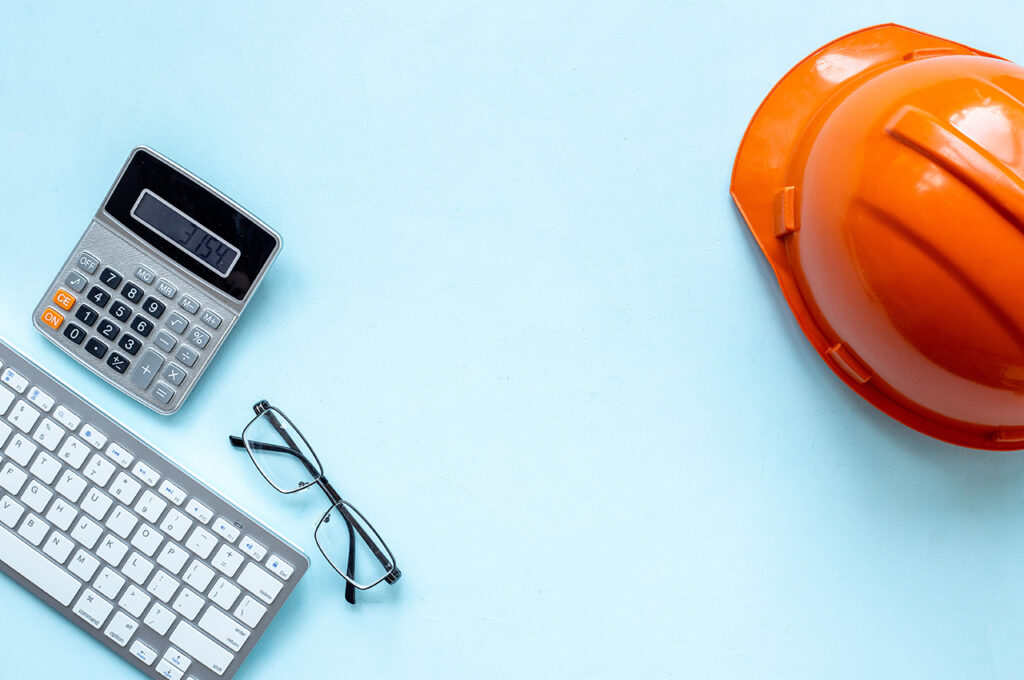 a hardhat, calculator and keyboard representing registering as a cis subcontractor
