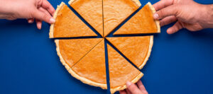 hands taking pieces of pie to represent taking dividends