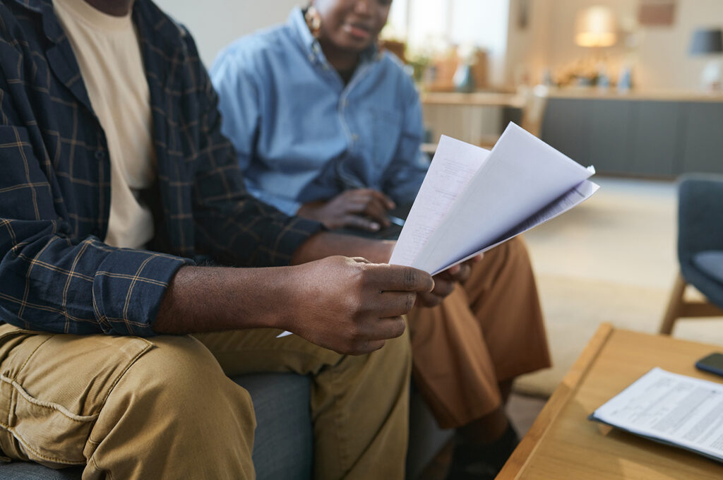 civil partners discussing inheritance tax for married couples on the sofa whilst checking their finances