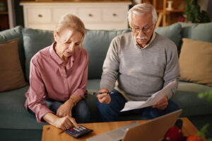 a retired couple calculating inheritance tax on pensions on the sofa at home
