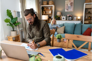 a businessman making notes about side hustle tax changes at the dining table
